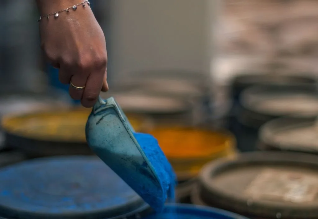 Mano che raccoglie del colore blu